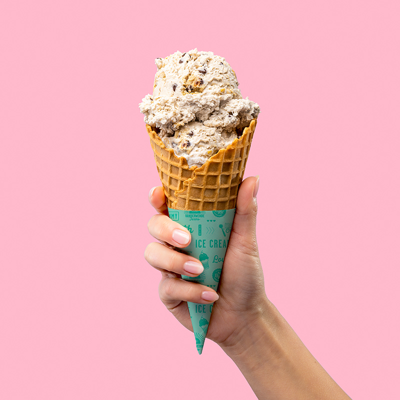 ice cream cone in hand on pink background